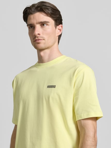 Männermodel trägt Herren T-Shirt mit Label-Print Modell 'Baine' von WOODBIRD in Hellgelb, Reine Baumwolle, Regular-Fit, Nahaufnahme Oberkörper.