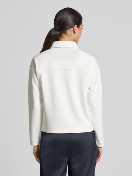 Frauenmodel trägt Jacke mit Umlegekragen und Brusttaschen von monari in Weiß, gerader Schnitt, feine Textur, Ganzkörperansicht Rückansicht.