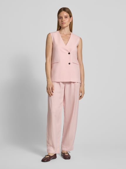 Frauenmodel trägt High Waist Stoffhose aus Viskose-Mix Modell 'Franciska' von MSCH Copenhagen in zartem Rosa, Barrel Fit mit Leinen-Viskose-Anteil, Gesäßtaschen, Bundweite 36 cm, Innenbeinlänge 79 cm, Ganzkörperansicht von vorne