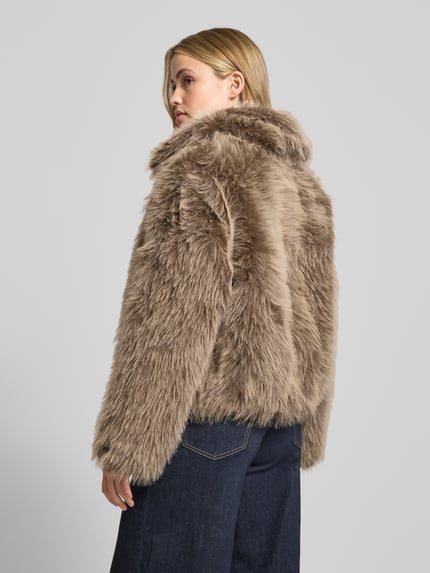 Kobiece model prezentuje Jacke aus Kunstfell mit Reißverschluss od Stefanel, kolor beżowy, tekstura futrzana, regular fit, widok z tyłu.