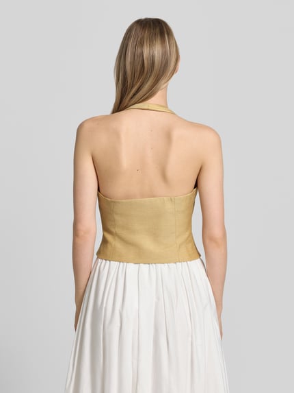 Vrouwenmodel draagt bodywarmer met halter en V-hals van comma, materiaalmix met linnen, getailleerd model, ruglengte maat 36: 21 cm, schouderbreedte 41 cm, borstwijdte 37 cm, kleurenmix beige en wit, gladde textuur, geheel achteraanzicht