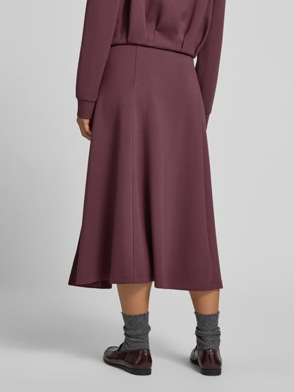 Vrouwenmodel draagt Midirok met elastische band van Christian Berg Woman in bordeaux, elastische materiaalmix met modal, los model, midilengte, bandwijdte maat S: 80 cm, geheel van achteren te zien