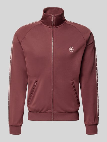 Produktfoto, Trainingsjacke mit aufgesetztem Band auf Raglanärmeln von REVIEW, krój regular fit, logo na piersi, stójka, zamek błyskawiczny, kieszenie na zamek, kolor bordowy, materiał gładki, Szerokość w rozmiarze M: 65 cm, długość rękawa w rozmiarze M: 65 cm