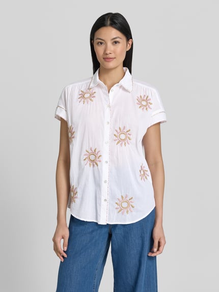 Vrouwenmodel draagt Regular Fit Bluse im Allover-Look mit Stitchings van Christian Berg Woman van puur katoen, overhemdkraag, knoopsluiting, wit met geborduurde motieven, ruglengte bij maat 36 65 cm, mouwlengte bij maat 36 5 cm, all-over look, ganzlichaamsvooraanzicht.