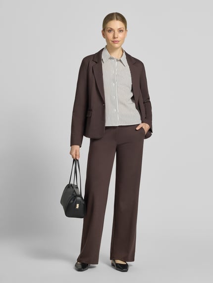 Frauenmodel trägt Straight Fit Stoffhose mit Viskose-Anteil Modell 'Nanni' von FREE/QUENT in Dunkelbraun, glatte Textur, Damen Stoffhose, Ganzkörperansicht von vorne.