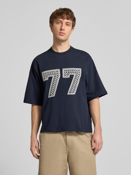 Męski model nosi T-Shirt mit Ketten-Stickerei und Rundhalsausschnitt von REVIEW, bawełna, krój relaxed fit, długość tyłu 65 cm, całkowity widok z przodu