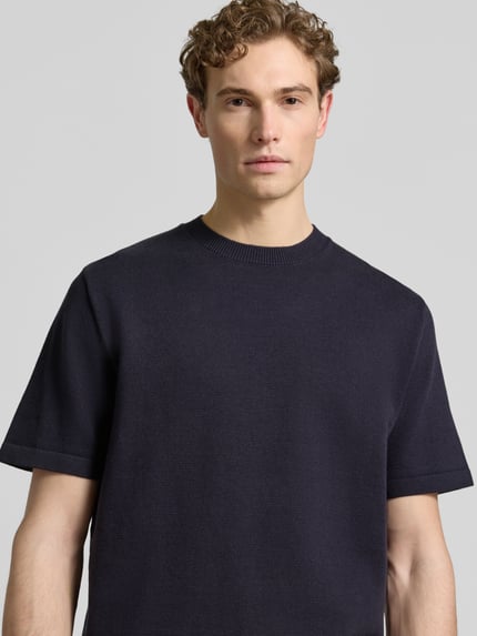 Männermodel trägt Strickshirt mit Label-Detail Modell 'MILANO' von Jack & Jones Premium, dunkelblau, Baumwoll-Mix, Nahaufnahme Oberkörper.