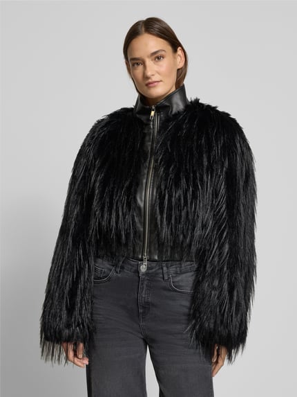 Frauenmodel trägt Slim Fit Jacke in Kunstfell-Optik Modell 'CECOOL' von BOSS, schwarz, unifarben, Stehkragen, Reißverschluss, Ganzkörperansicht von vorne