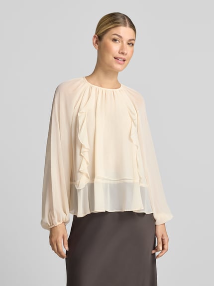 Vrouwenmodel draagt Bluse mit Raffungen van Christian Berg Woman Selection in crème, met Volants, los model, Plooien, elastische boordjes, blouse met lange mouwen, Ruglengte maat 36: 56 cm, Mouwlengte maat 36: 70 cm, Ganzkörperansicht van voren.