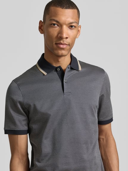 Mężczyzna model nosi Regular Fit Poloshirt mit Polokragen und kurzer Knopfleiste od bugatti z bawełny, detal z logo, długość tyłu 70 cm, Nahaufnahme Oberkörper