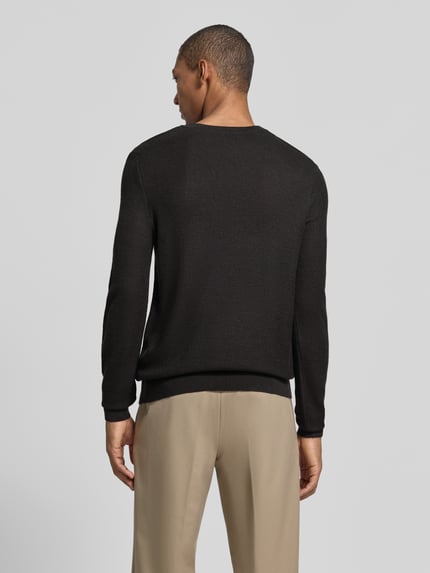 Männermodel trägt Strickpullover aus Wollmix Modell 'Bennino' von JOOP! in Unifarbe, Strickoptik, Ganzkörperansicht Rückansicht.