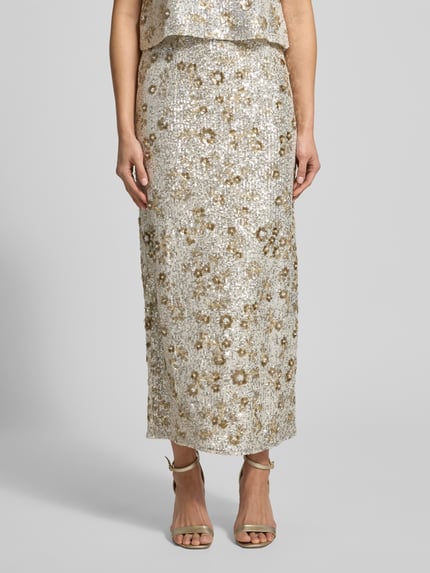 Frauenmodel trägt High Waist Maxirock mit Pailletten Modell 'Magnolia' von MSCH Copenhagen, gerade Form, schimmernde Textur, Nahaufnahme Unterkörper.