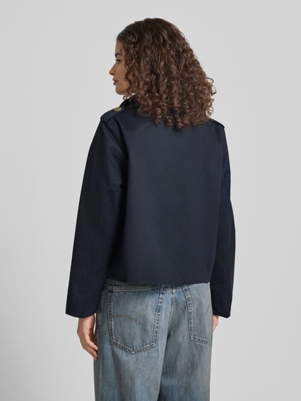 Frauenmodel trägt Regular Fit Trenchcoat mit Umlegekragen von Review aus Reiner Baumwolle, dunkelblau, Eingrifftaschen, Rückenansicht.