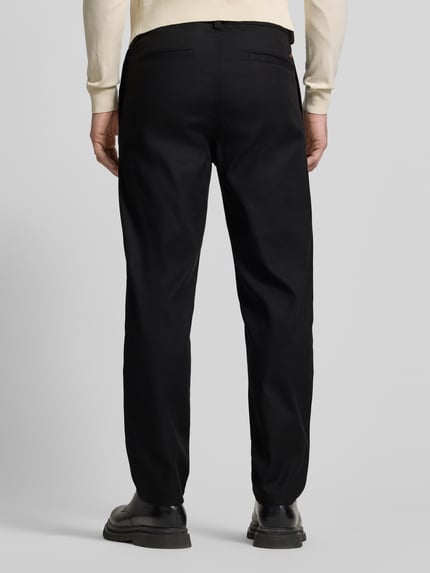 Männermodel trägt schwarze Tapered Chino mit Kordelzug Modell 'CHINO ST-P' von BOSS Orange, unifarben, Ganzkörperansicht Rückansicht.