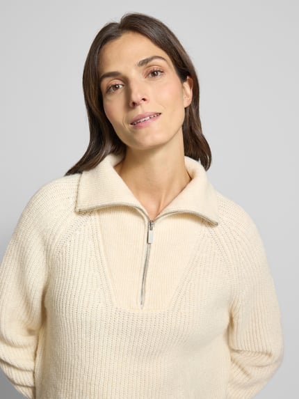 Kobiece model prezentuje Regular Fit Pullover mit Woll-Alpaka-Anteil Modell 'Poy' od OPUS w kremowym kolorze, dzianinowa faktura, zbliżenie na górę ciała.
