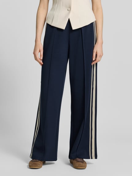 Frauenmodel trägt Jog Pants mit französischen Eingrifftaschen von Jake*s Casual, navy mit cremefarbenen Streifen, Wide Leg Fit, Nahaufnahme Unterkörper.