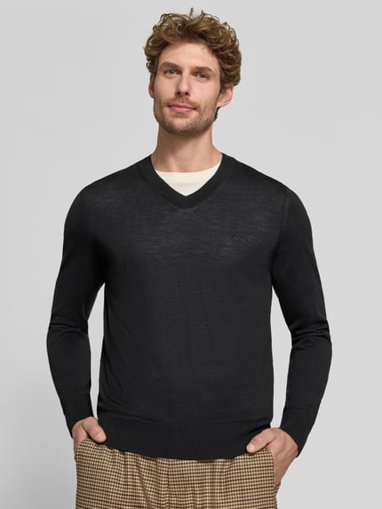 Männermodel trägt schwarzen Regular Fit Pullover aus reiner Schurwolle Modell 'H-Melba-L' von BOSS, Herren Pullover, Nahaufnahme Oberkörper.