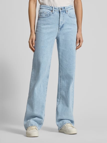 Kobiece model nosi Wide Leg Jeans aus Baumwoll-Mix Modell 'TESSA' od Vero Moda, efekt: jednolity kolor, krój wide fit, wysoki stan, naszywka z logo, wyhaftowane logo, wytłaczane logo, szlufki na pasek, zapięcie na guzik i ukryty zamek, 5 kieszeni, wykończenie: denim, mieszanka bawełny, jasnoniebieski odcień, tekstura denimowa; widok całej sylwetki z przodu.
