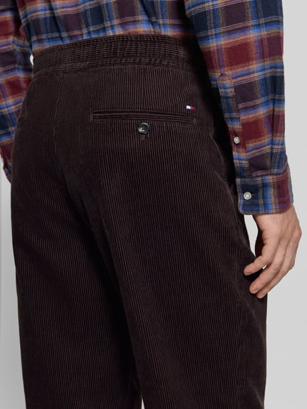 Mannenmodel draagt donkerbruine straight fit corduroy broek van katoen model 'DOVER' van Tommy Hilfiger, detailopname rugaanzicht, Heren corduroy broek.