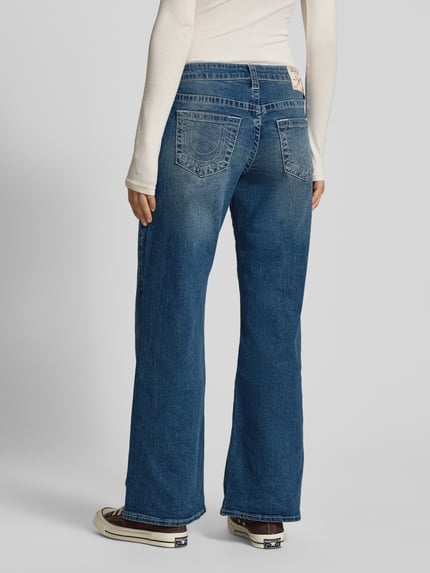 Vrouwenmodel draagt Jeans met wijd been model 'BOBBY BAGGY' van TRUE RELIGION, blauwe used-look, katoen-elastaanmix, volledig zicht van achteren.