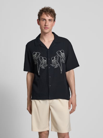 Mężczyzna nosi koszulę casualową Relaxed Fit Freizeithemd aus reiner Baumwolle Modell 'JACKSON' von Only & Sons, efekt: jednolity kolor, krój relaxed fit, kołnierzyk koszulowy, na całej długości listwa guzikowa, aplikacja: haft, zapięcie: listwa guzikowa 1-rzędowa, rękaw: krótki rękaw, wykończenie materiału: seersucker, materiał: bawełna; widok: całkowity z przodu.