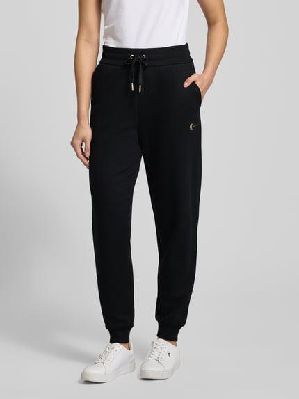 Kobieta modelka nosi czarne Sweatpants mit elastischem Bund von ARMANI EXCHANGE, luźny krój, bawełniany miks, widok całej sylwetki z przodu.