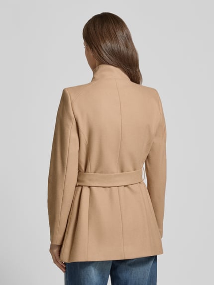 Vrouwenmodel draagt Kurzmantel uit wolmix met strikceintuur Model 'ROSESS' van Ted Baker, met opstaande kraag en labeldetail, regular fit, ruglengte maat 36: 72 cm, schouderbreedte 42 cm, borstwijdte 42 cm, mouwlengte 61 cm, kleur beige, rugaanzicht.