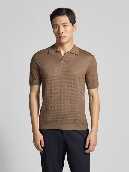 Männermodel trägt Slim Fit Poloshirt mit Lyocell-Anteil von Emporio Armani in Braun, Kurzarm, Strick-Optik, Ganzkörperansicht von vorne.