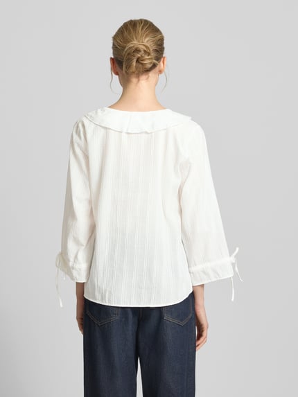 Frauenmodel trägt Regular Fit Bluse mit Volants von Smith and Soul, reine Baumwolle, Strukturmuster, Rundhalsausschnitt, 3/4-Arm, Rückenlänge 59 cm, Ärmellänge 48 cm, weiße Farbe, horizontale Streifenstruktur, Ganzkörperansicht Rückansicht.
