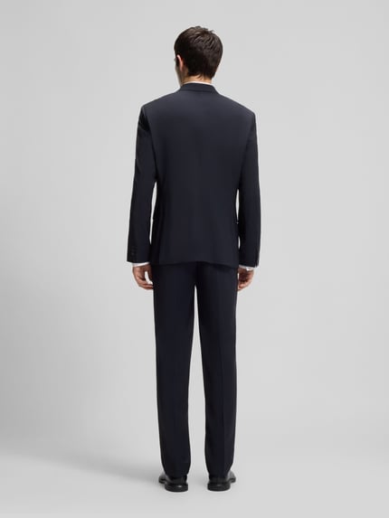 Männermodel trägt Slim Fit Anzugsakko aus Woll-Mix Modell 'ARTI' von HUGO, kolor melanż, krój slim fit, Ganzkörperansicht Rückansicht.