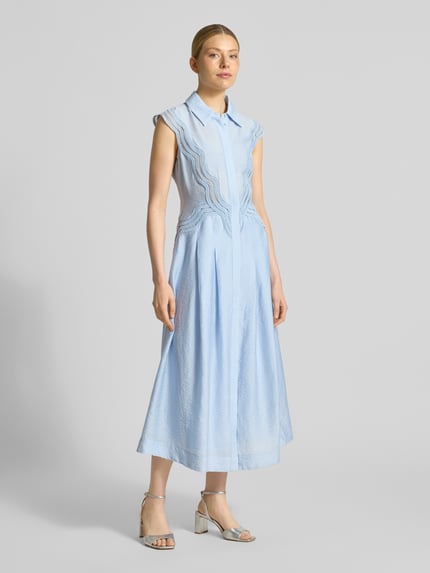 Frauenmodel trägt Hemdblusenkleid aus Modal-Mix mit Spitze Modell 'COLE' von Copenhagen Muse in Hellblau, A-Linie, Midikleid, verdeckte Knopfleiste, strukturierte Oberfläche, Ganzkörperansicht von vorne. Rückenlänge bei Größe S: 128 cm, Brustweite bei Größe S: 41 cm.