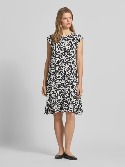 Vrouwenmodel draagt Regular fit zomerjurk van pure viscose model 'BARRI' van Pieces met all-over print, schmetteringsmouwen, crepe textuur, knielang, ronde hals en knoopsluiting, frontaal volledig lichaamsaanzicht.