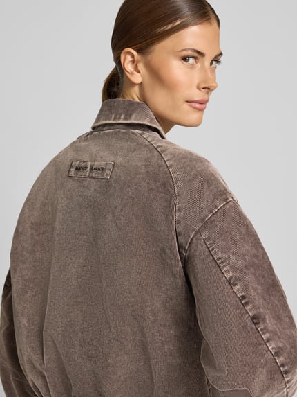 Vrouwenmodel draagt Jacke aus Cord mit Eingrifftaschen Modell 'KELLA' van Samsøe Samsøe in bruin corduroy, regular fit, detailopname rugaanzicht.