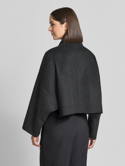 Frauenmodel trägt Jacke aus Woll-Mix mit Reißverschluss Modell 'ELSTOW' von DRYKORN in Dunkelgrau, boxy Fit, Rückenansicht, KI-modifiziertes Bild.