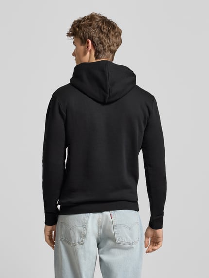 Männermodel trägt Regular Fit Hoodie aus Baumwoll-Mix Modell 'CERES' von Only & Sons, Optik: Unifarben Schwarz, Rückansicht Ganzkörperansicht.