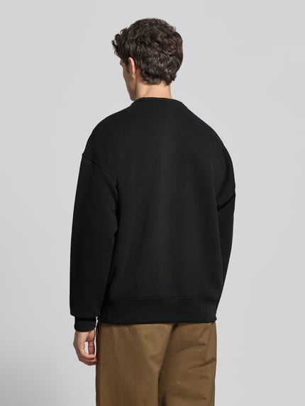 Männermodel trägt Sweatshirt mit Logo-Print von POLO RALPH LAUREN aus Baumwollmix, unifarben, Rundhals, lange Ärmel, Ganzkörperansicht Rückansicht.