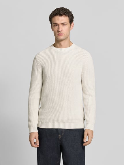 Męski model nosi Regular Fit Strickpullover aus reiner Baumwolle od s.Oliver RED LABEL, kremowa dzianina, proste kształty, gładka faktura, Ganzkörperansicht von vorne.
