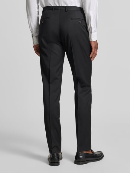 Männermodel trägt Slim Fit Anzughose mit Bügelfalten Modell 'Move Apollo' von DIGEL aus Schurwoll-Elasthan-Mix, Gesäßtaschen, Rückansicht.