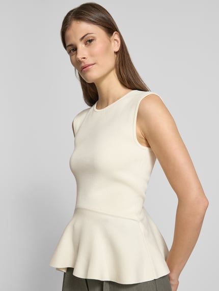 Frauenmodel trägt Regular Fit Top aus Viskose-Mix Modell 'FILLO' von BOSS in Unifarben mit Schößchen-Saum, Feinstrick, Ganzkörperansicht von vorne.