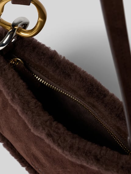 Produktfoto, Handtasche mit Teddyfell Modell 'OLLIE' von Staud in Braun, Reißverschluss, goldfarbene Akzente, weiche Textur, Detailaufnahme, Damen Handtasche, Label-Detail, Maße: 25 x 13 x 7 cm, Schulterriemen 45 cm.