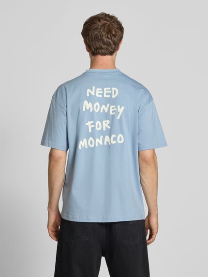 Männermodel trägt Loose Fit T-Shirt aus reiner Baumwolle Modell 'MONEY' von Only & Sons, Optik: Unifarben, Statement-Print, Ganzkörperansicht Rückansicht.