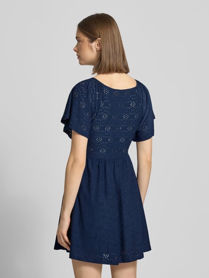 Vrouwenmodel draagt Only vrijetijdsjurk model 'Smilla' in donkerblauw met etskanteffect, getailleerde pasvorm, minilengte, korte mouw, rechte zoom. Ganzkörperansicht Rückansicht.