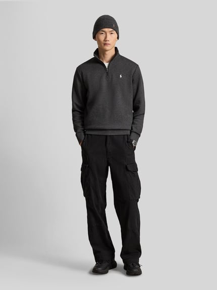 Männermodel trägt Relaxed Fit Troyer aus Baumwoll-Mix von Polo Ralph Lauren in dunklen Farben, Ganzkörperansicht von vorne.