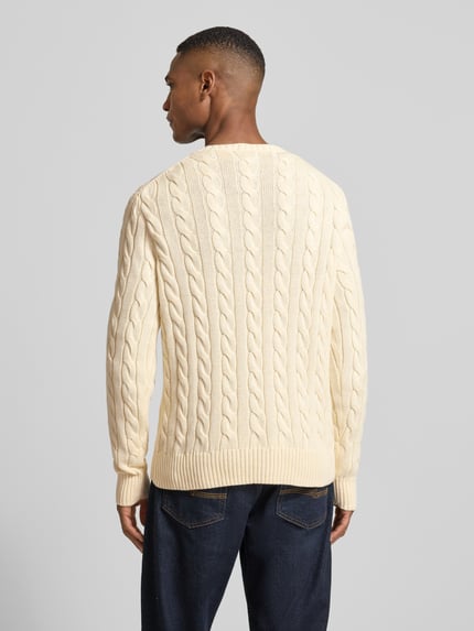 Männermodel trägt Strickpullover mit Label-Stitching von Polo Ralph Lauren in Creme, Reine Baumwolle, Regular-Fit, gerippte Abschlüsse, Rundhalsausschnitt, Rückenlänge bei Größe M 70 cm, Ärmellänge 73 cm, Ganzkörperansicht Rückansicht.