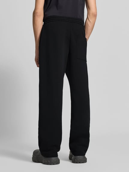 Männermodel trägt Sweatpants mit elastischem Bund von Moose Knuckles, Baumwollmischung, gerade Form, schwarze Farbe, Ganzkörperansicht Rückansicht.