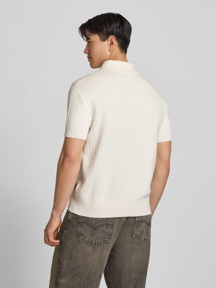 Männermodel trägt Regular Fit Poloshirt aus reiner Baumwolle von Tommy Jeans in Two-Tone-Optik, Strick, Rückansicht Ganzkörperansicht.