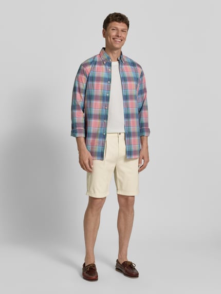 Männermodel trägt Chino Shorts mit Gesäßleistentaschen von Lerros in Beige, Baumwoll-Mix mit Stretch, Ganzkörperansicht von vorne.