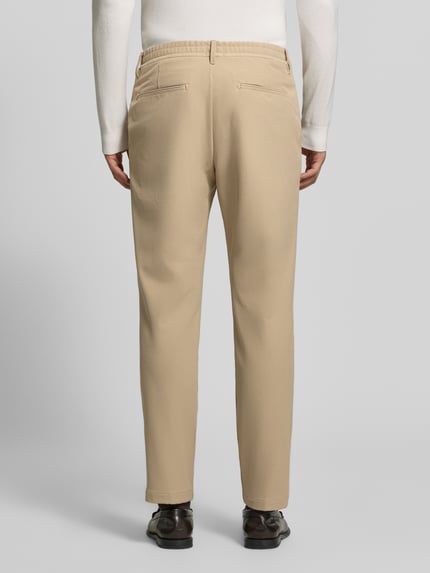 Männermodel trägt sandfarbene Regular Fit Bundfaltenhose mit Bügelfalten Modell 'Lui' von Strellson, Webware, Rückansicht Ganzkörperansicht.