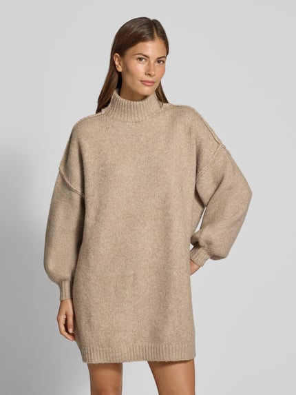 Frauenmodel trägt Strickkleid mit Stehkragen und überschnittenen Schultern von Apricot, gerader Schnitt, Woll-Mix, sandbeige, Ganzkörperansicht von vorne.