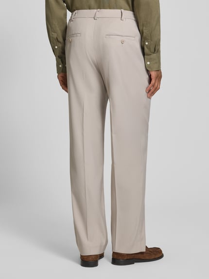 Männermodel trägt Straight Fit Hose mit Viskose-Anteil von Jake*s in Beige mit Bundfalten, Eingriffstaschen, Knopf-Reißverschluss, Ganzkörperansicht Rückansicht.